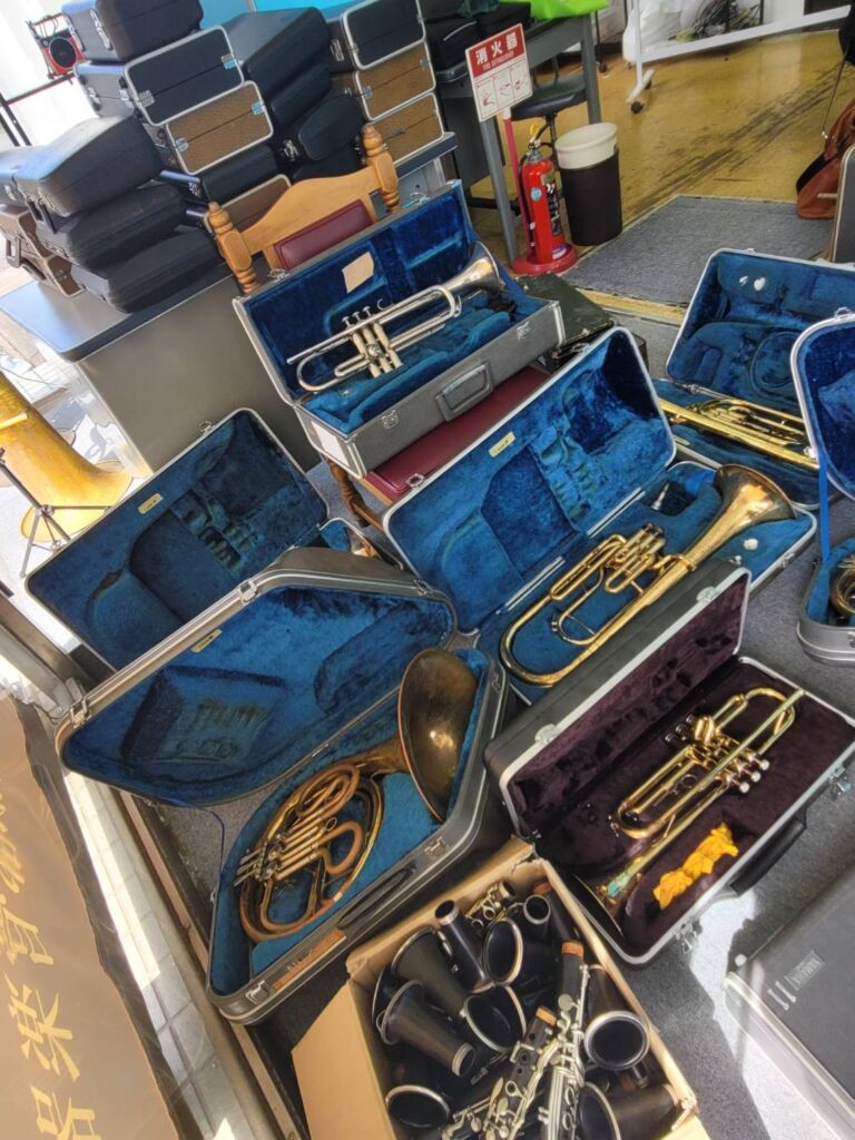 ジャンク楽器市に並ぶトランペットやフレンチホルンなどの管楽器
